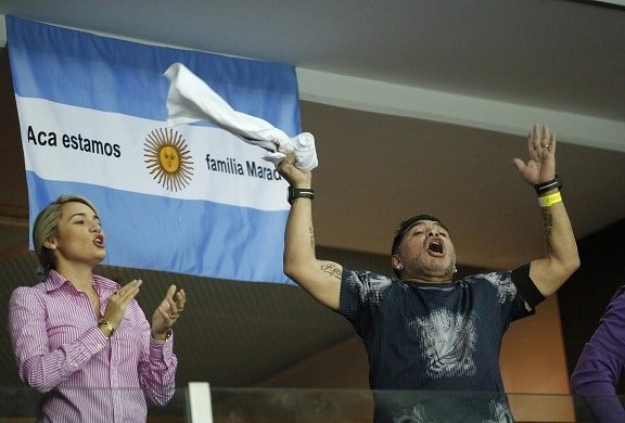 Argentinian soccer legend Diego Maradona cheers from the stands along with his partner Rocio Oliva during the Davis Cup finals tennis singles match between Argentina's Juan Martin Del Potro and Croatia's Marin Cilic in Zagreb, Croatia, Sunday, Nov. 27, 2016. (AP Photo/Darko Bandic)